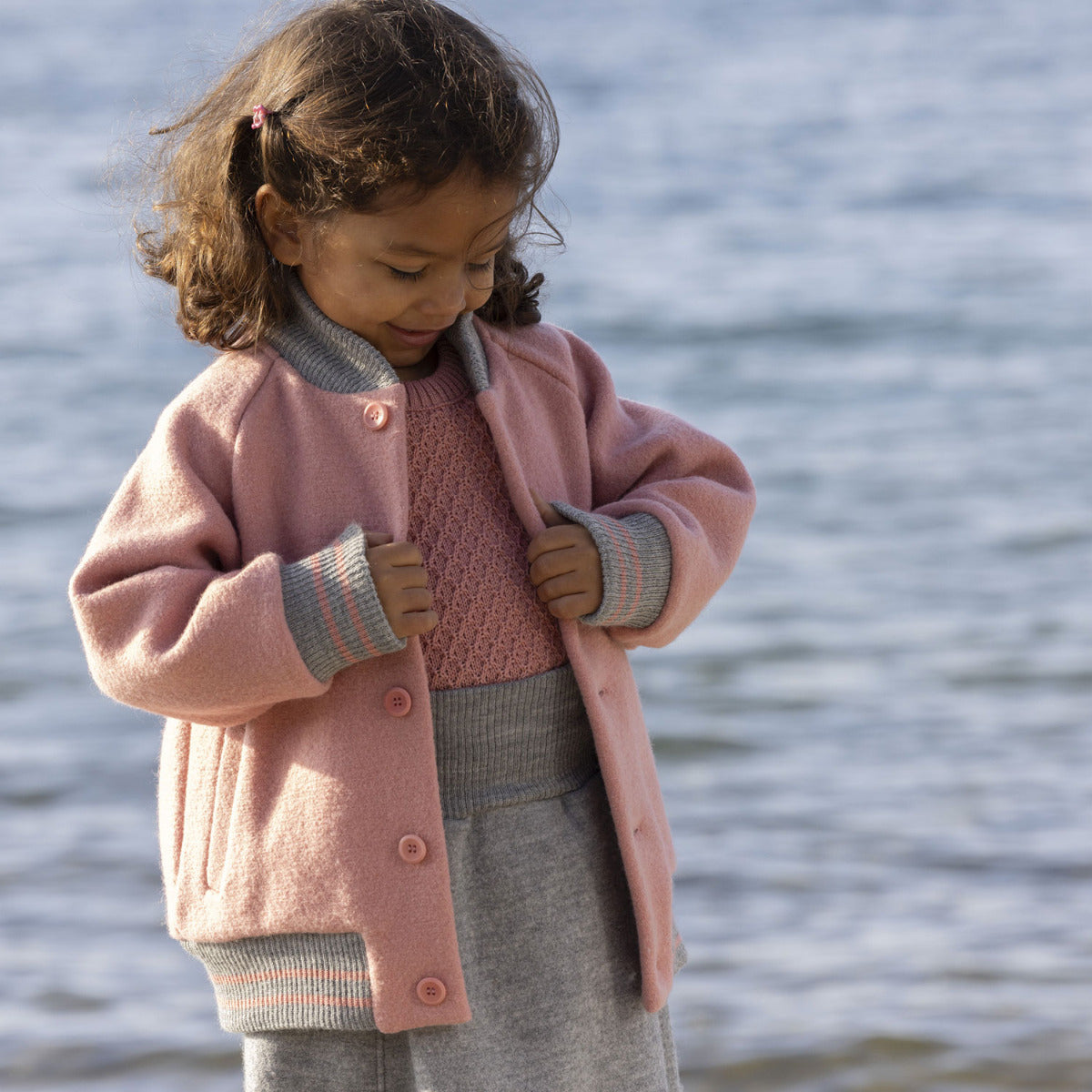 Découvrez la veste teddy Disana Soft Pink en laine mérinos bouillie bio : chaude, douce et respirante, idéale pour protéger votre enfant en hiver.